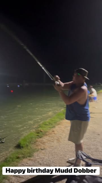 Mudd Dobber casting a fishing rod beside the water at night