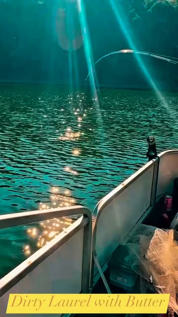 Sunbeams across Laurel River beside a fishing boat